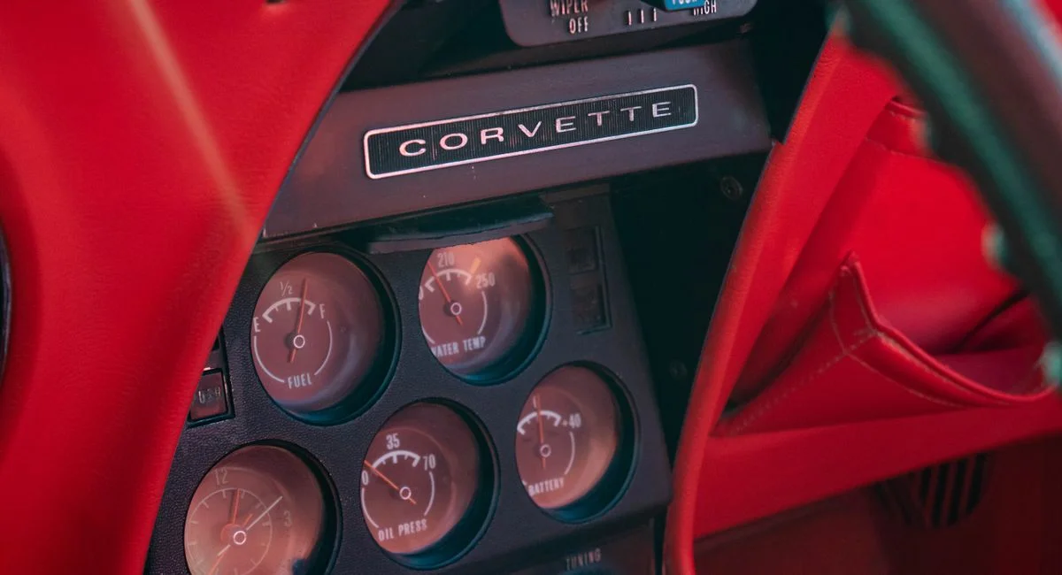 Close-up of a vintage Chevrolet Corvette dashboard showcasing gauges and details.
