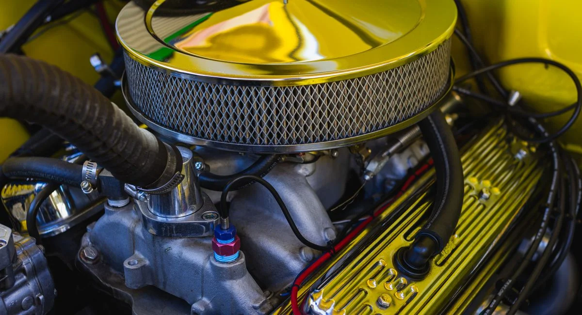 Detailed view of a car engine featuring chrome elements and intricate mechanical parts.