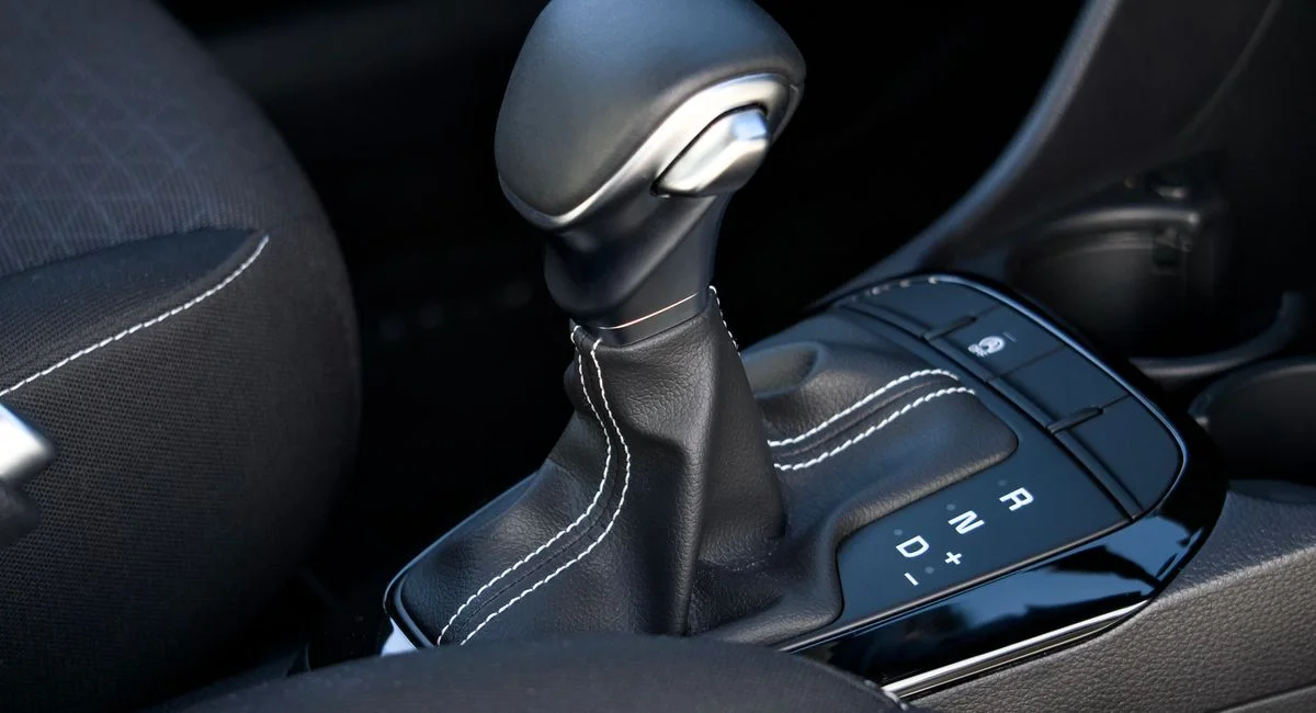 Close-up of a modern car gear lever in a Kia vehicle, showcasing quality design and functionality.