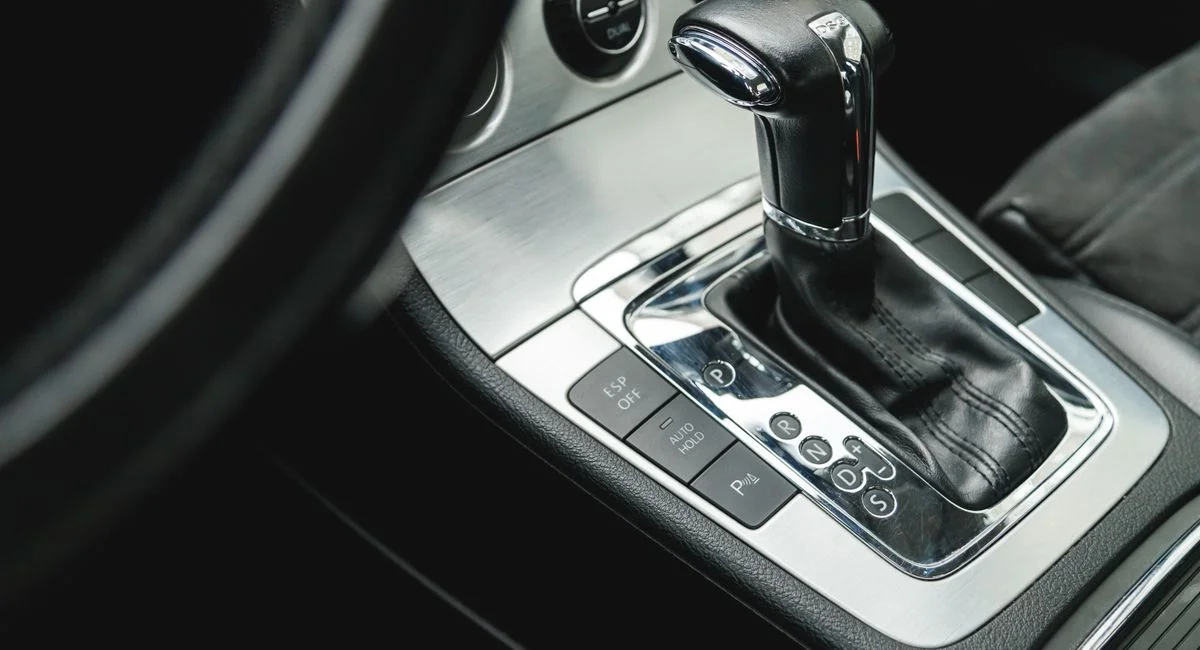 Detailed view of a modern car's automatic gear shifter inside vehicle interior.