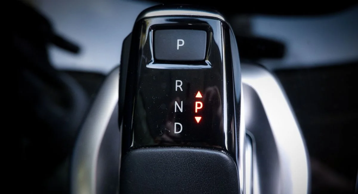 Detailed view of a modern automatic car gear shifter displaying P, R, N, D settings.