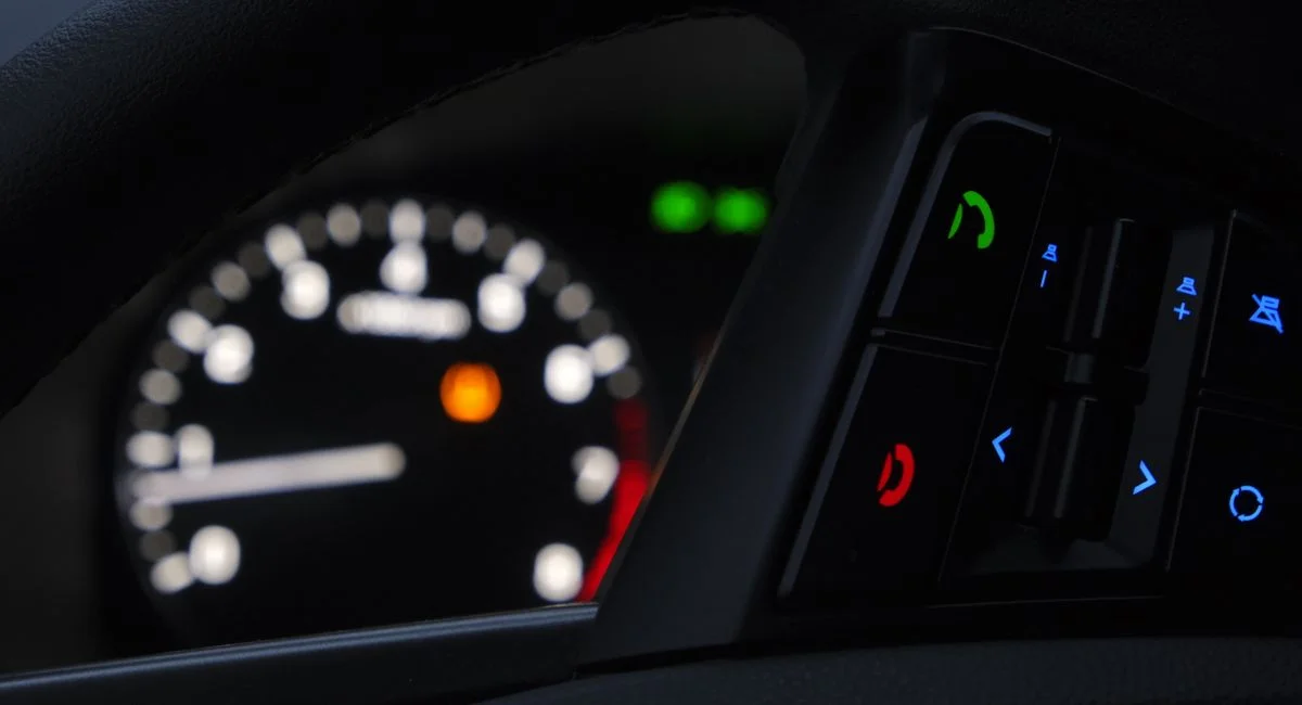 Close-up of a modern car dashboard displaying illuminated controls and gauges.